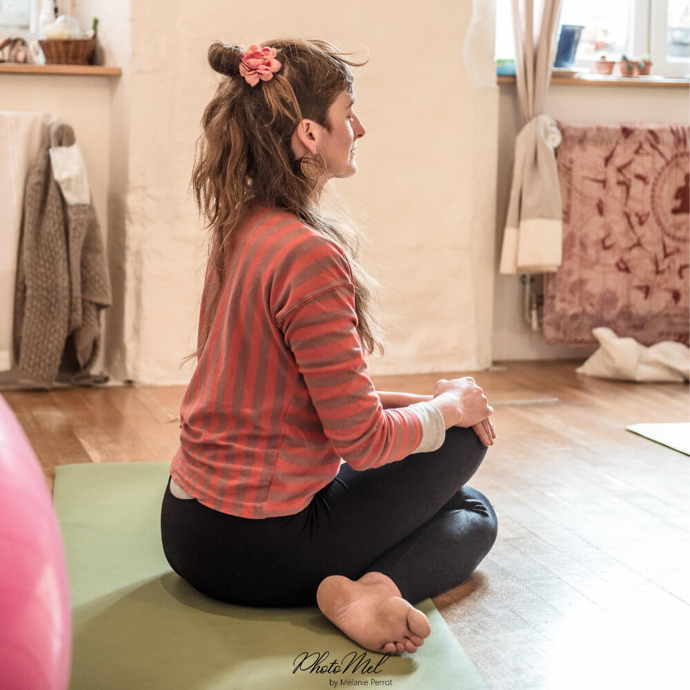 Hélène assise, dans une posture de yoga